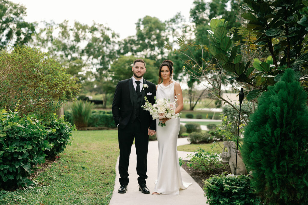 bride and groom standing in a garden by west palm beach wedding photographer