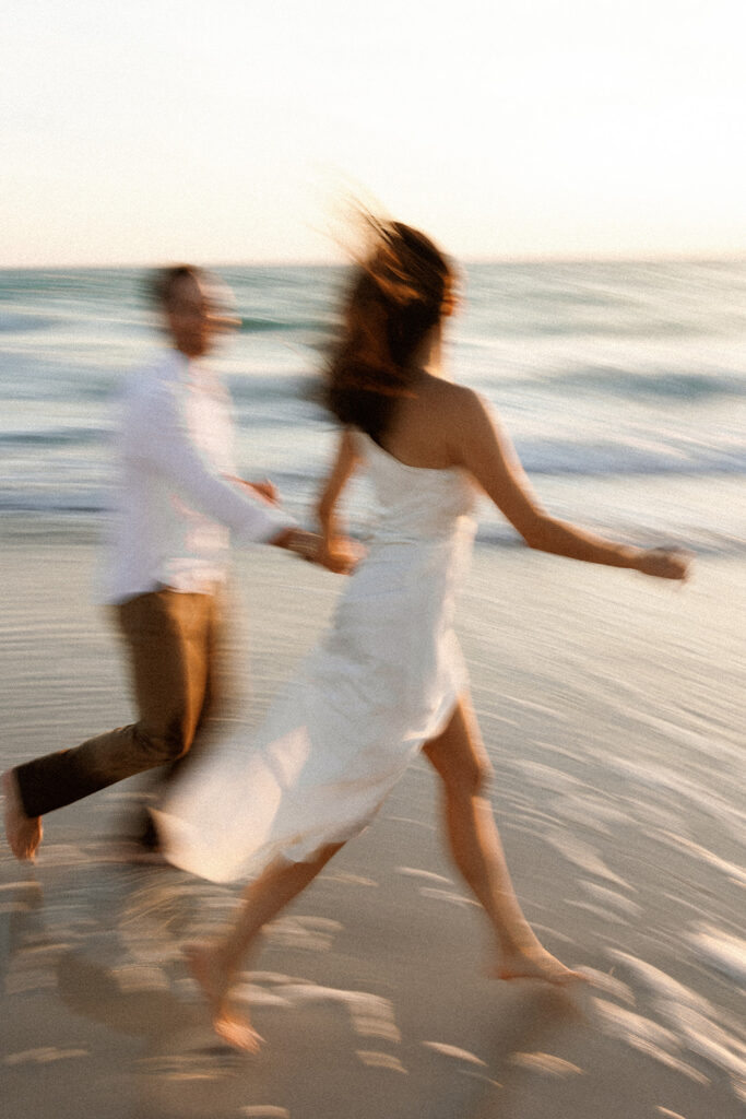 Couple on beach for engagement photos in naples at Via Miromar Beach