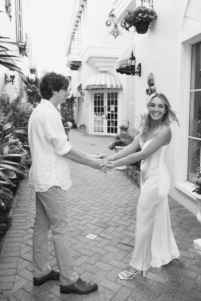 couple holding hands for Naples florida downtown engagement photo session