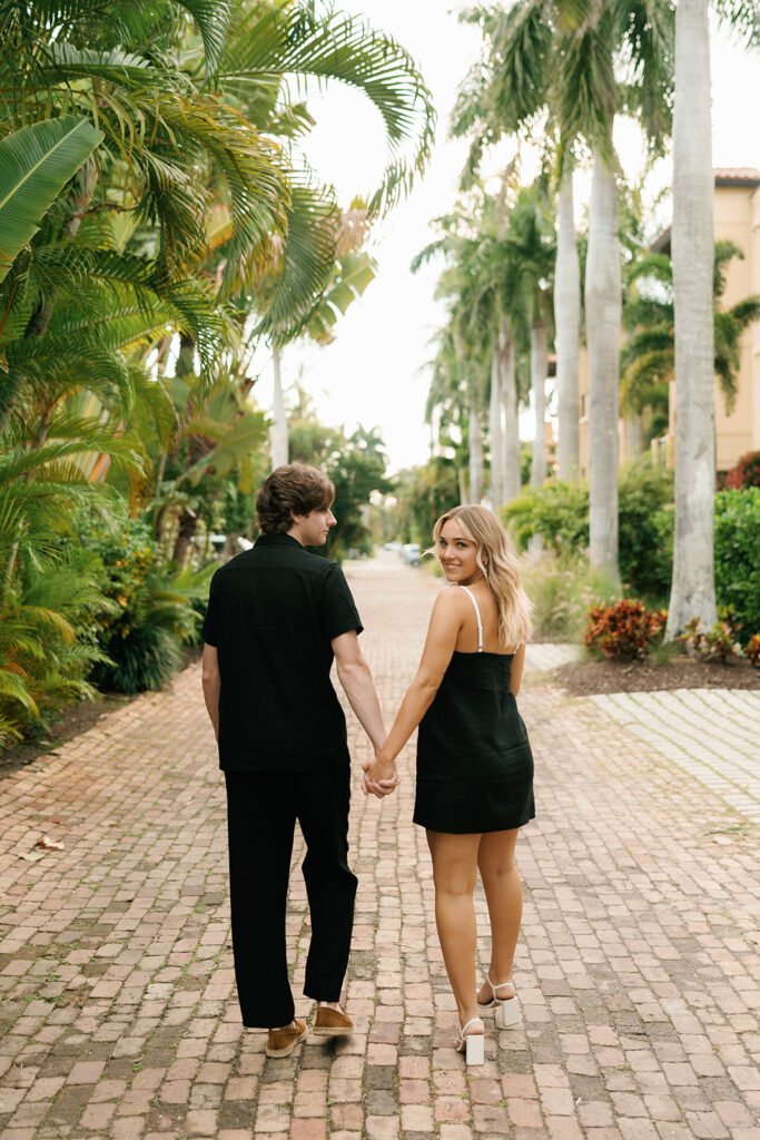 couple walking away for downtown naples beach engagement session