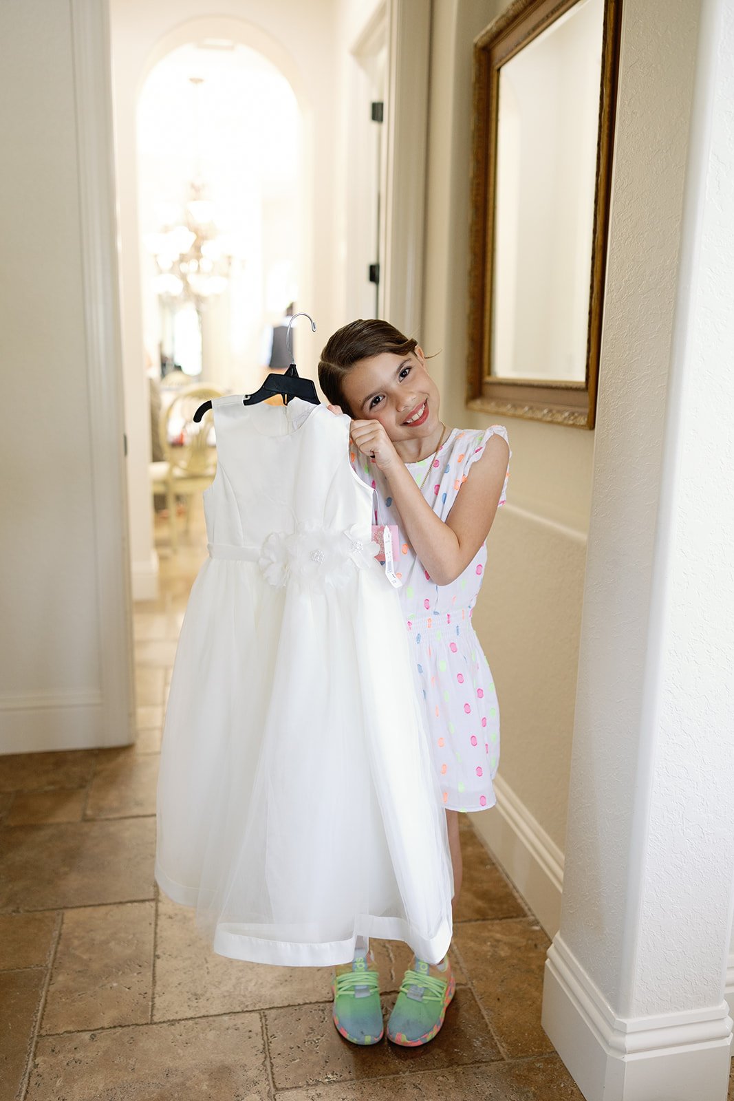 a flower girl posing with her dress at the la casa toscana wedding venue