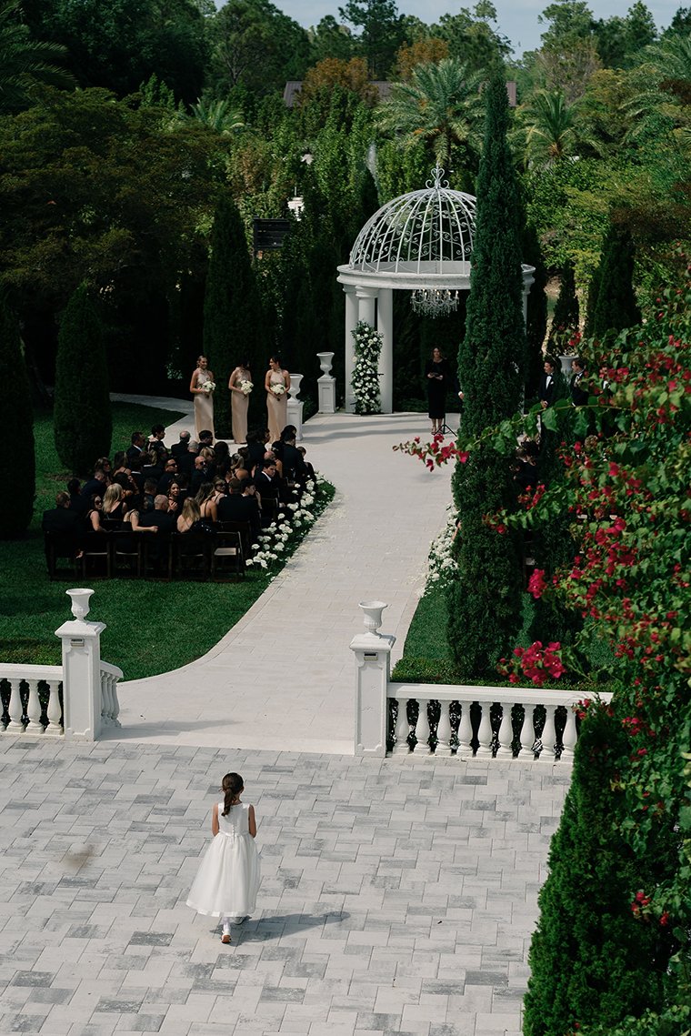 the flower girl walking down the aisle for the la casa toscana wedding