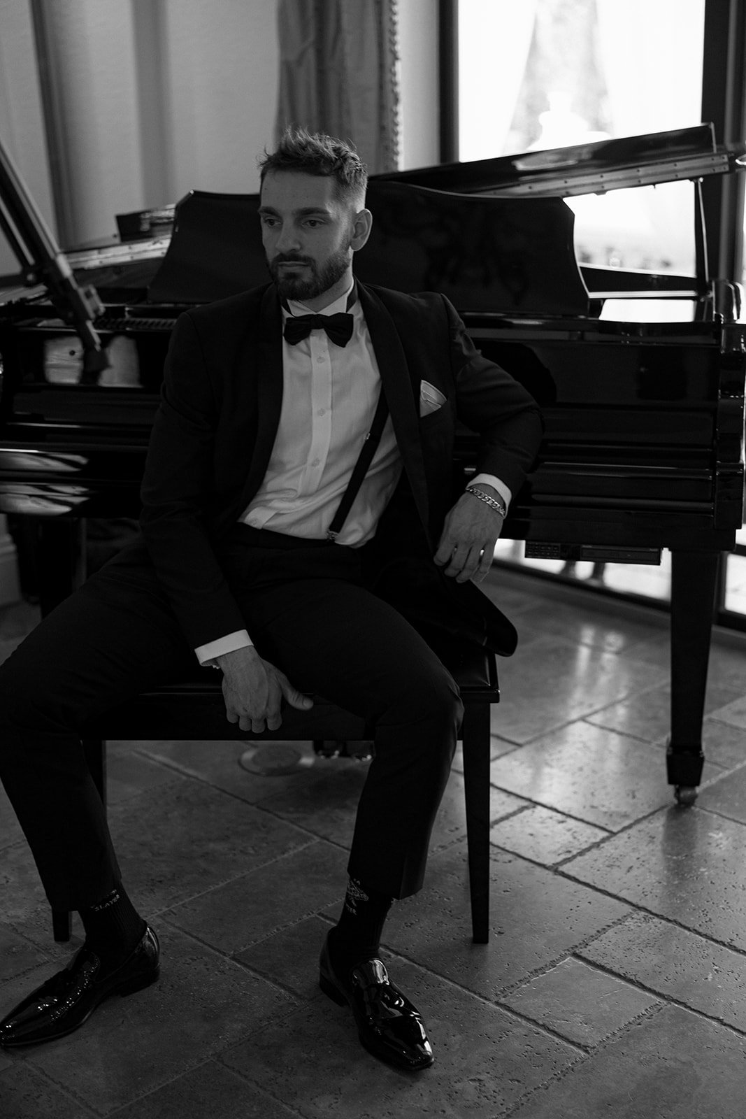 a groomsmen sitting by the piano for a la casa toscana photo