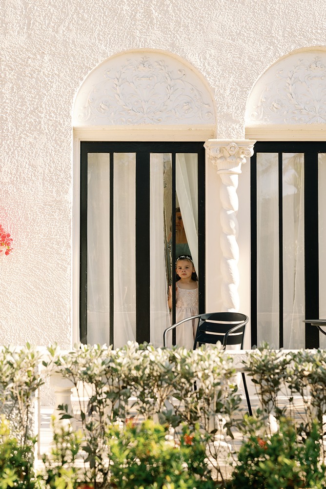 the flower girl peeking out at the bride and groom at the Alderman House wedding venue
