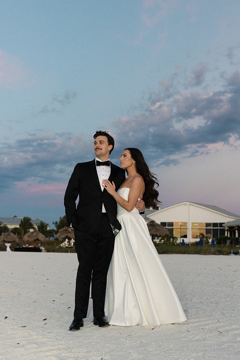 the bride and groom on the beach at the hideaway beach club