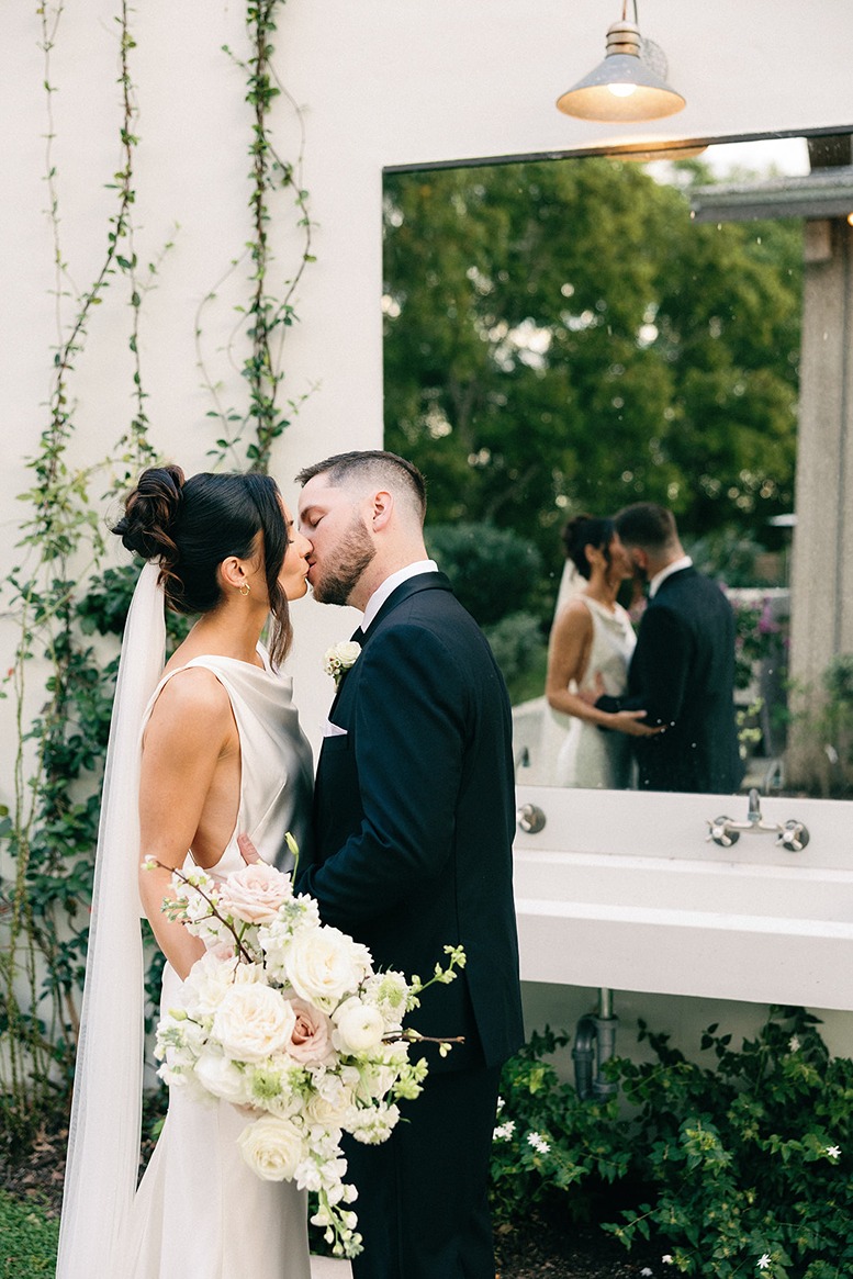 the bride and groom kissing at the white trail club an outdoor wedding venue in south florida