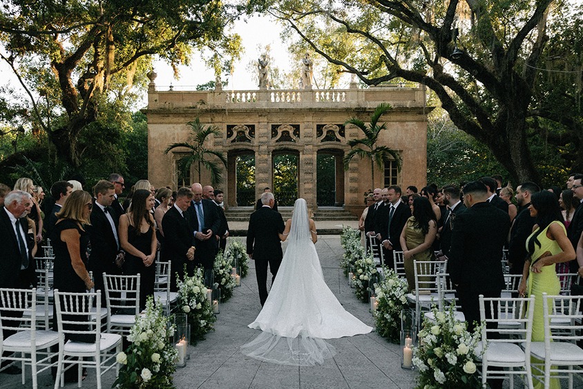 The bride walking down the aisle at Vizcaya a wedding venue in south florida