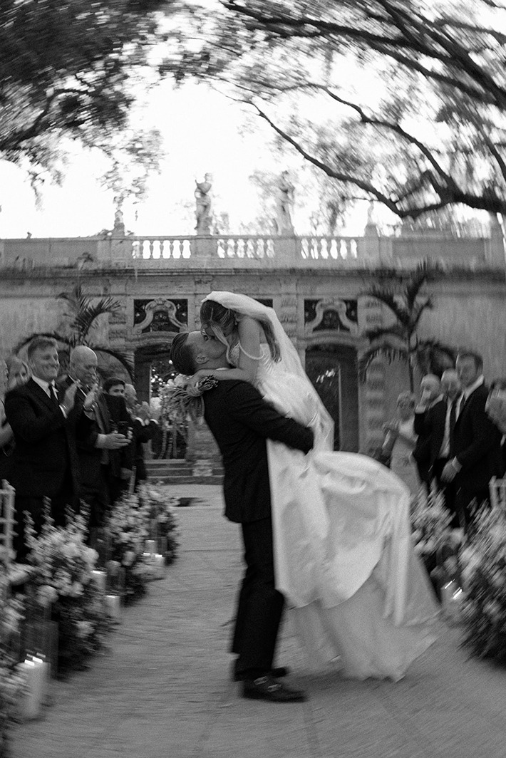 the bride and groom walking down the aisle at their outdoor wedding venue in south florida, Vizcaya