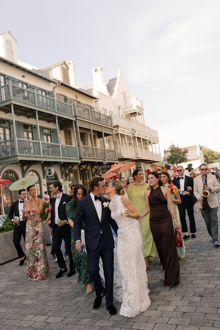 the bride and groom walking down the street at their rosemary beach wedding