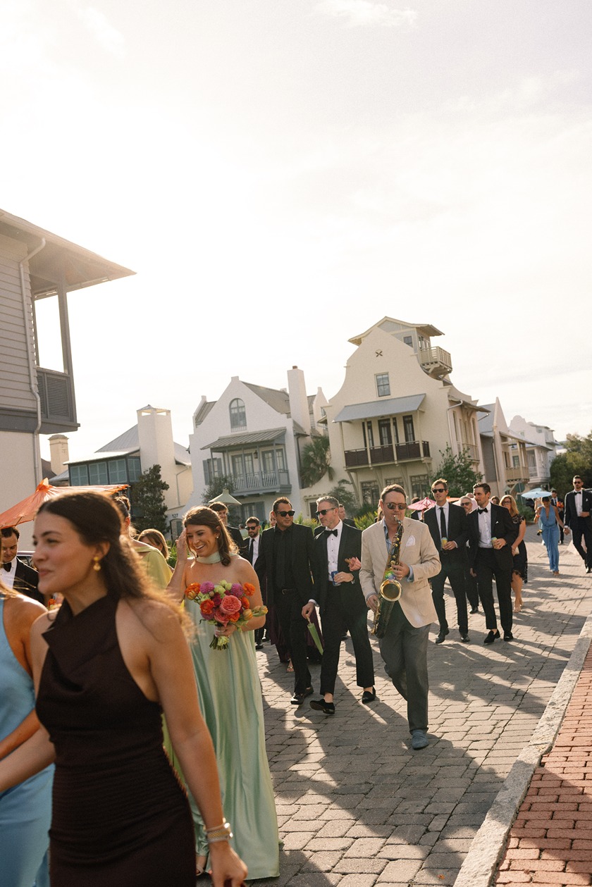 the wedding guests walking down the beach at a rosemary beach wedding